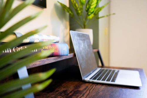 a laptop computer sitting on a table next to books at Studio 44 - Spacious Studios - City Centre Location - Contractor Friendly - Free WiFi - Smart TV - Desk Space - Well Designed - Communal Garden in Peterborough