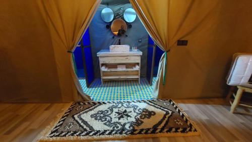 a dressing room with a mirror and a rug at Hamada Activities Luxury Camp in Merzouga
