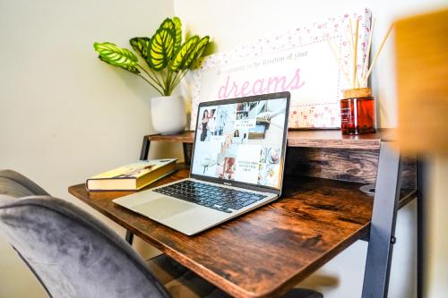 a laptop computer sitting on a wooden table at Studio 44 - Spacious Studios - City Centre Location - Contractor Friendly - Free WiFi - Smart TV - Desk Space - Well Designed - Communal Garden in Peterborough