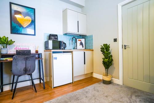 a kitchen with a white refrigerator and a desk at Studio 44 - Spacious Studios - City Centre Location - Contractor Friendly - Free WiFi - Smart TV - Desk Space - Well Designed - Communal Garden in Peterborough
