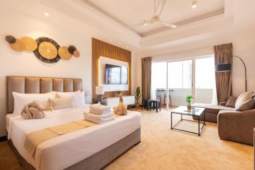 a bedroom with a large bed and a couch at Negombo Beach - The Breeze by Roshi in Negombo