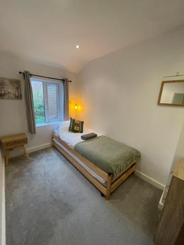 a bedroom with a bed and a window at Tucked away house in Macclesfield in Macclesfield