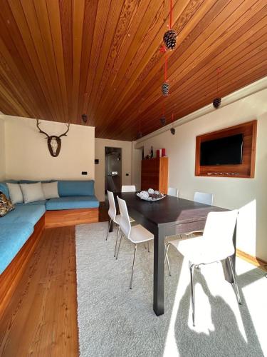 a dining room with a table and chairs and a couch at Antagnod 10 in Antagnod