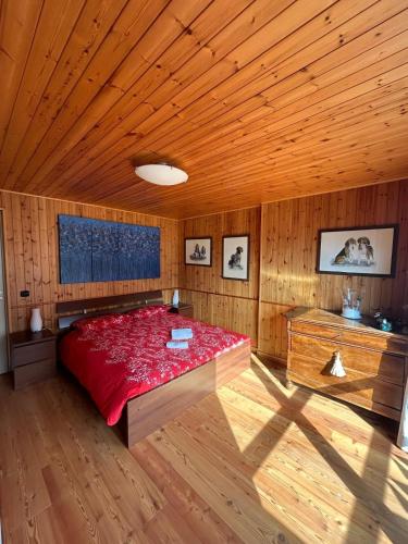 a bedroom with a red bed in a wooden room at Antagnod 10 in Antagnod