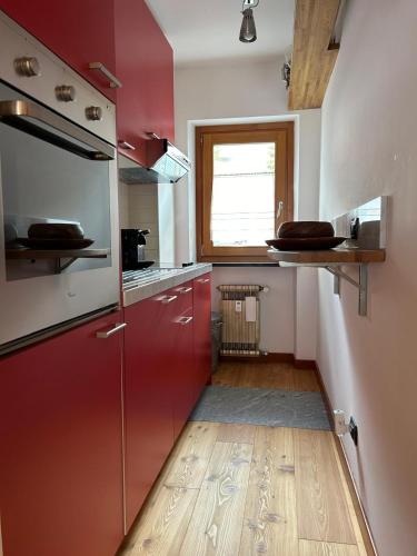 a kitchen with red cabinets and a wooden floor at Antagnod 10 in Antagnod