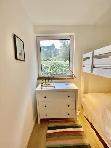 a small bedroom with a dresser and a window at Ferienbungalow Arne am Wald in Woltersdorf