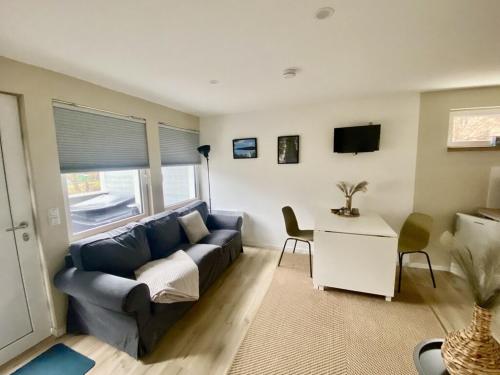 a living room with a blue couch and a table at Ferienbungalow Arne am Wald in Woltersdorf