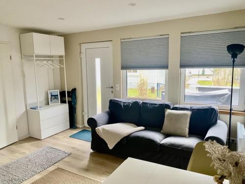 a living room with a blue couch in front of a window at Ferienbungalow Arne am Wald in Woltersdorf