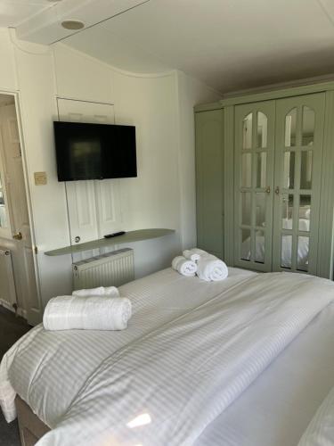 a bedroom with a large white bed with towels on it at The Vogue Lodge in Buxton