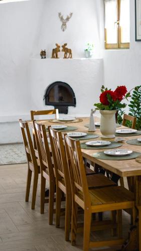 a dining room with a table with chairs and a fireplace at La poale de munte in Vistisoara