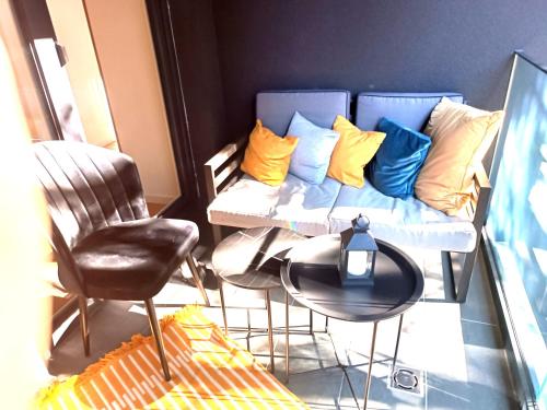 ein Sofa mit bunten Kissen, einem Tisch und einem Stuhl in der Unterkunft Oaza1 in Trnovo