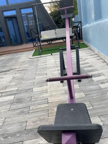 a pink exercise bike on a patio with a table at Aframezing Gabala in Gabala