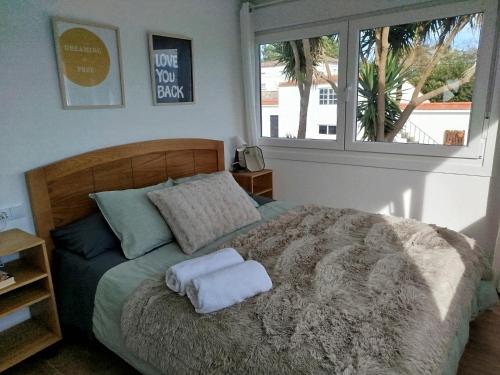 a bedroom with a bed with two towels on it at La de Simón in A Guarda