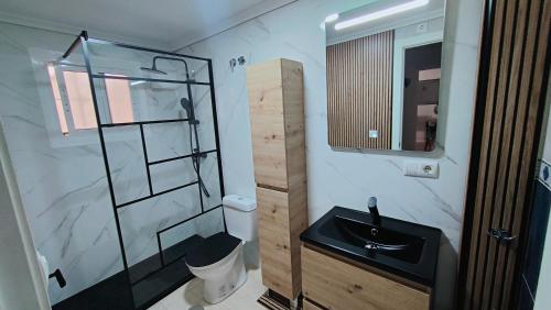 a bathroom with a sink and a glass shower at BUNGALOW ACOGEDOR EN GRAN ALACANT in Gran Alacant