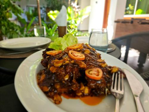 a plate of food on a table with a fork at Nihaali Maldives in Kudarikilu