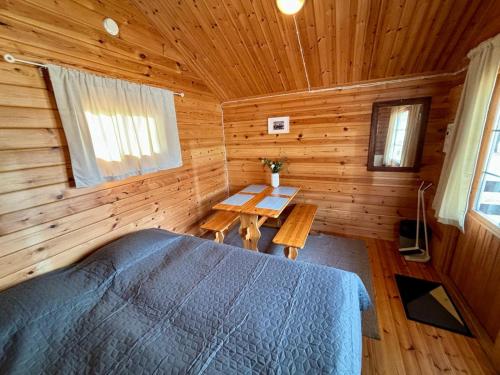 ein Schlafzimmer mit einem Bett in einer Holzhütte in der Unterkunft Vuohimäki Camping Savonlinna in Savonlinna