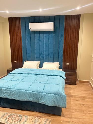 a bedroom with a bed with a blue wall at Rihana pyramids hotel in Cairo