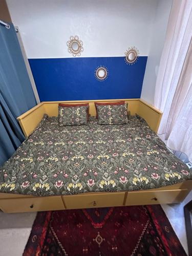 - un petit lit dans une chambre aux murs bleus dans l'établissement YOUSRA Appartement, à Poitiers