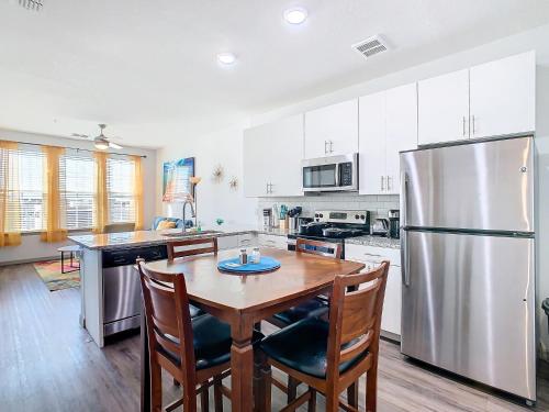 a kitchen with a wooden table and a stainless steel refrigerator at Your Dream Apartment Stay in Kissimmee