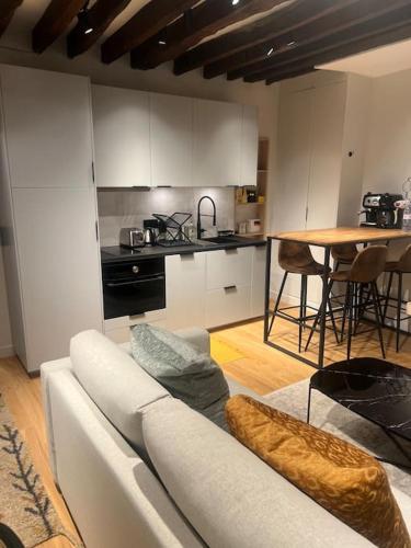 un salon avec un canapé blanc et une cuisine dans l'établissement Magnifique appartement Le Marais Paris, à Paris