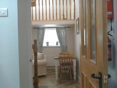ein Raum mit einem Stuhl und einem Tisch und einem Fenster in der Unterkunft Quarry Cottage in Consett