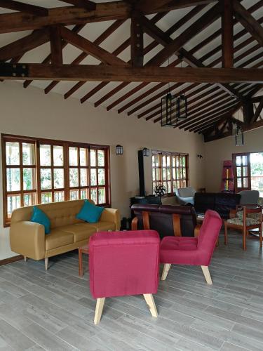 a living room with couches and tables and windows at Finca MonteSer in Jardin