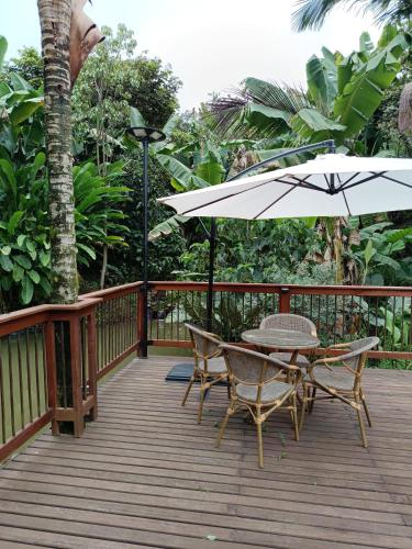 a wooden deck with a table and an umbrella at Finca MonteSer in Jardin