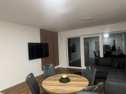 ein Wohnzimmer mit Tisch und Couch in der Unterkunft Schöne Ferienwohnung in Buxtehude- Zentral -Lade Säule -6Person in Buxtehude