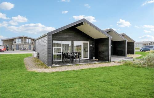 a small black house with a grass yard at Two-Bedroom Holiday Home Ringkøbing 04 in Ringkøbing