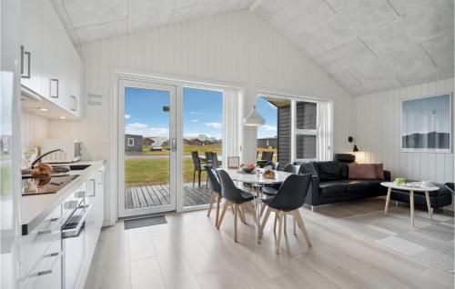 a kitchen and living room with a table and chairs at Two-Bedroom Holiday Home Ringkøbing 04 in Søndervig
