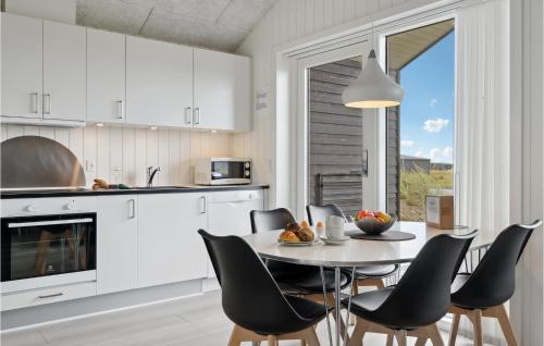 a kitchen and dining room with a table and chairs at Two-Bedroom Holiday Home Ringkøbing 04 in Ringkøbing