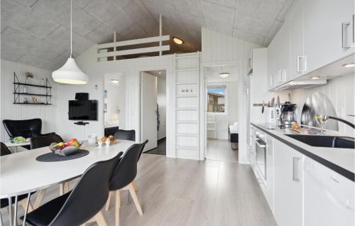a kitchen and living room with a table and chairs at Two-Bedroom Holiday Home Ringkøbing 04 in Ringkøbing