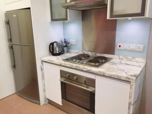 a kitchen with a stove and a refrigerator at WOW Strait Quay Luxury Suite Room in Tanjong Tokong