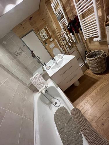 une grande salle de bain avec une baignoire et un lavabo dans l'établissement Studio front de neige pelevos, à Isola