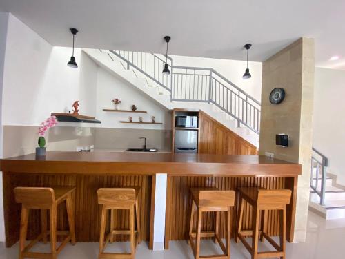 a kitchen with a wooden counter and stools at Villa Dua Warna Dencarik in Lovina
