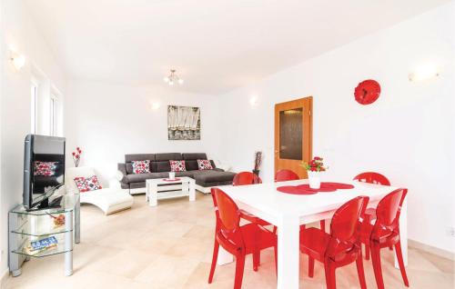 a living room with a white table and red chairs at Two-Bedroom Apartment In Ratac in Orasac
