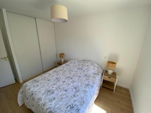 une chambre avec un lit avec une couette bleue et blanche dans l'établissement Maison neuve entre mer et forêt, à Saint-Jean-de-Monts