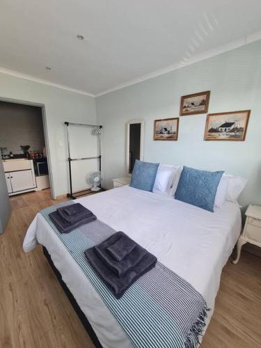 a bedroom with a large white bed with towels on it at H & E Sunset Paradise in Fisherhaven