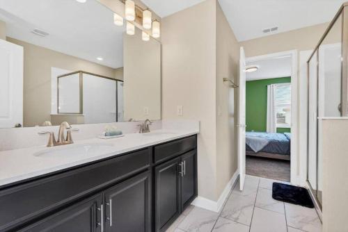 ein Badezimmer mit Waschbecken und großem Spiegel in der Unterkunft Luxury Champions gate 8Br Villa Champions Gate in Davenport