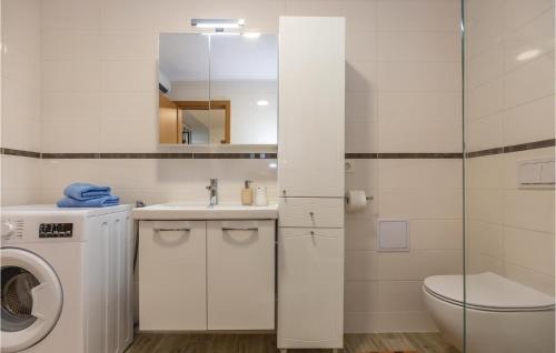 a bathroom with a sink and a washing machine at Awesome Home In Ploce With Jacuzzi in Ploče