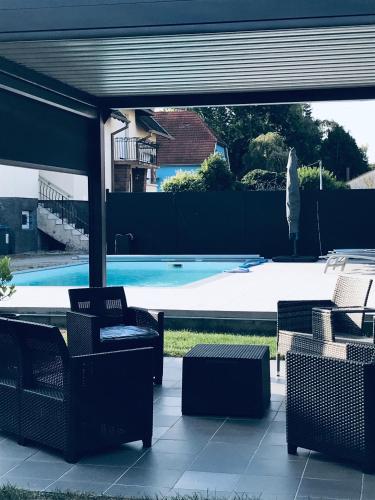 un patio avec des chaises et une piscine dans l'établissement Chambre d hôtes chez Carol et Patrick, à Gundershoffen