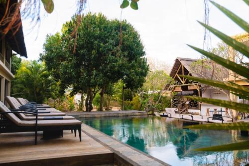 a pool with lounge chairs next to a house at The Garden Lodge Pereybere - Piscine & Jardin in Pereybere
