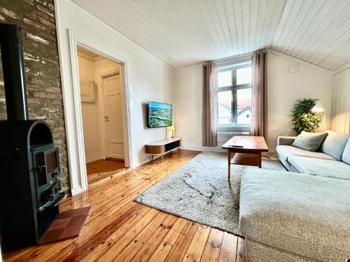 a living room with a couch and a tv at Sentralt i Sarpsborg in Sarpsborg