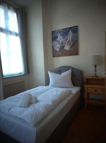 a bedroom with a white bed with a window at Schloss Oppurg in Oppurg