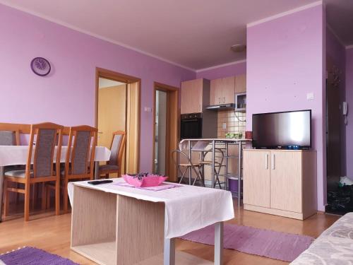 a living room with a table and a kitchen at Apartments 1A JollyKop in Kopaonik
