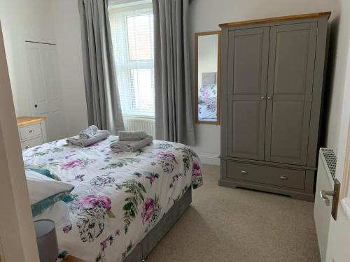 a bedroom with a bed and a cabinet and a window at Harbour Haven in Berwick-Upon-Tweed