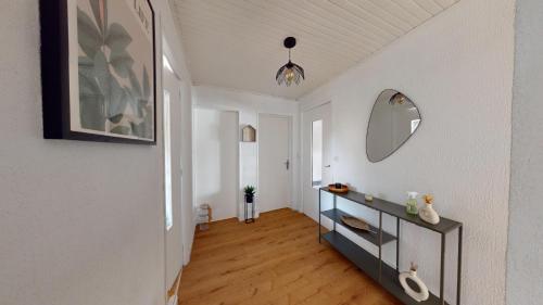 un couloir avec une table et un miroir mural dans l'établissement Escapade en bord de mer, à Port-de-Bouc