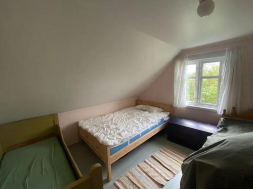 Un dormitorio pequeño con una cama y una ventana. en Norwegian house, en Hestnes