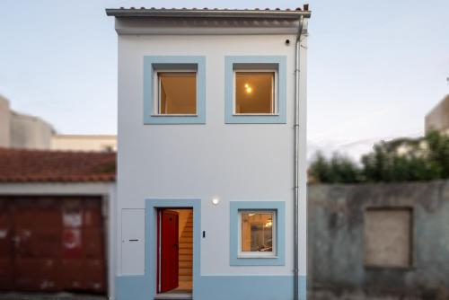 a white house with two windows and a door at Casa dos Pescadores in Esposende