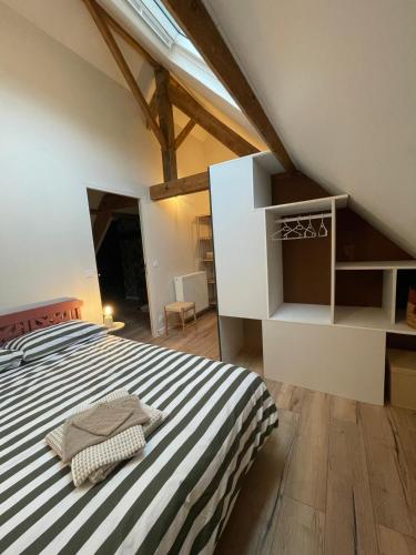 - une chambre avec un grand lit et des draps rayés dans l'établissement le gite de la pommeraie, à Le Bois-Robert